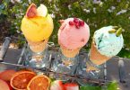 drei Eiswaffeln in einem Waffelständer ein gelbes ein rosanes und ein grünes