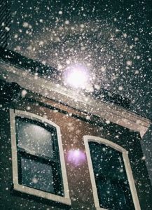 Foto nach oben auf den Schneefall beleuchtet von einer Laterne