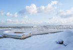 ein Fischerboot an einem beschneitem Strand