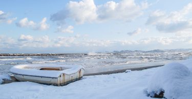 ein Fischerboot an einem beschneitem Strand