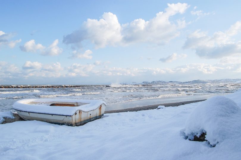 ein Fischerboot an einem beschneitem Strand