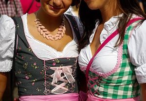 Oberkörper zweier Frauen die ein traditionelles Dirndl tragen, eine Grau mit Rosinen Blümchen und die andere grünkariert mit rosa Schleifen