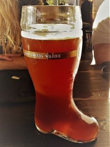 Bierglass in Form von Stiefel voll mit Bier auf einem Holztisch