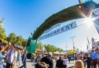 Eintritt ins Gelände des Oktoberfestes: ein grosser Heckenbogen und darunter steht auf zwei verschiedenen Schildern Herzlich willkommen zum Oktoberfest