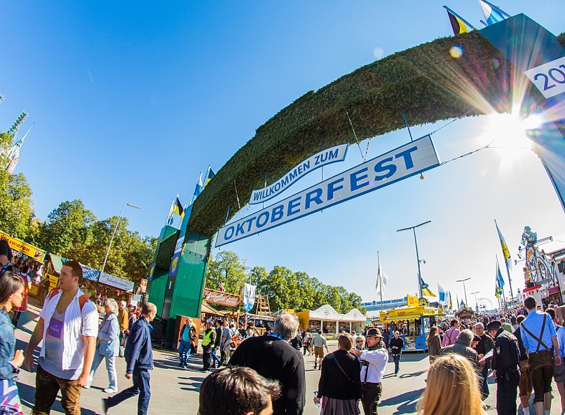 Eintritt ins Gelände des Oktoberfestes: ein grosser Heckenbogen und darunter steht auf zwei verschiedenen Schildern Herzlich willkommen zum Oktoberfest