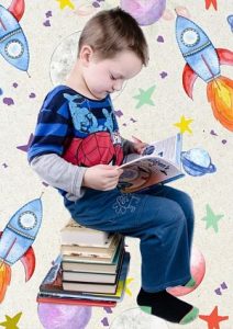 ein Junge mit einem Spiderman-T-Shirt der auf einem Turm von Büchern sitzt und ein Buch ansieht