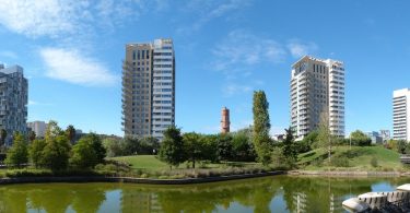 drei Hochhäuser mit Wohnungen an der diagonal de mar mit einem Teich davor und von bäumen umgeben