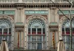 Der Eingang der Teatre del Liceu in Barcelona, beige Fassade mit hellgrünen Details und einer spanischen Flagge links und einer katalanischen Flagge rechts von der Tür