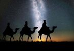 in der Wüste sind drei Kamele mit drei Männern zu sehen wie sie durch die nacht ziehen, vermutlich die heiligen drei Könige