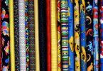 aufgerollte Stoffe in verschiedensten Farben und Mustern die nebeneinander aufgeregt sind