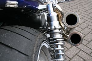 zu sehen ist ein Auspuff eines blauen Motorrads und Teil des Hinterreifens