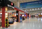 die Halle eines Flughafens und der sich zahlreiche Duty Free Läden aneinander reihen