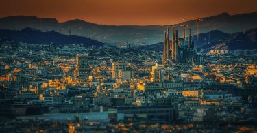 panoramafoto von Barcelona bei Dämmerung rechts im Bild ist die Sagrada Familia zu sehen