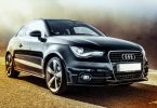 ein schwarzer Audi mit weissem Kennzeichen der auf einer Straße steht
