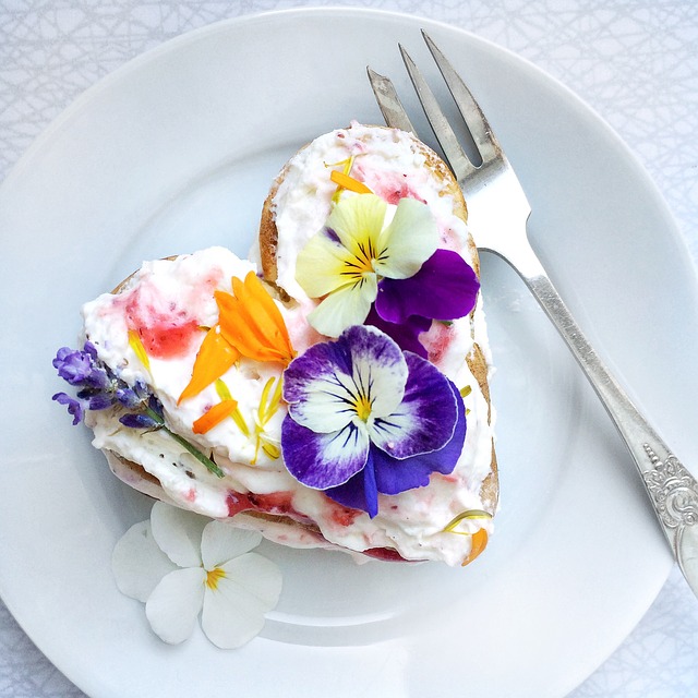 ein herzförmiges Brötchen mit einer weißen creme und Blumen darauf