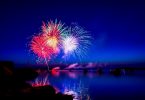 Sicht auf ein farbenfrohes Feuerwerk bei nacht über dem Meer