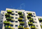 ein sechsstöckiges Wohngebäude mit gelben Balkonen