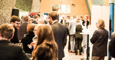viele Leute die auf einer Messe stehend miteinander reden