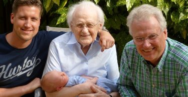 vier generationen die in die Kamera lächeln, baby, Vater, opa und Uropa