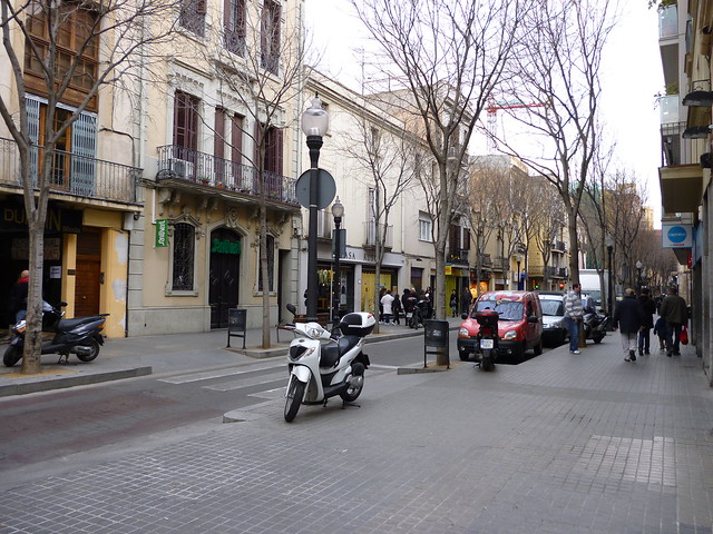 eine Straße im Bezirk Sant Andreu mit vielen Bäumen und geparkten Autos