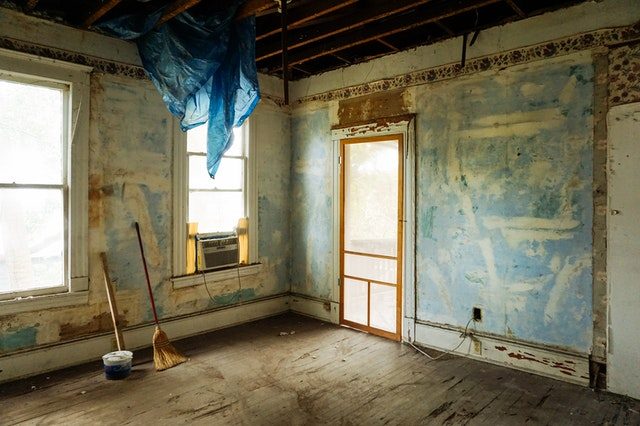 eine etwas ältere Wohnung ohne Tapeten an den Wänden und einer blauen Plastiktüte die von der Decke hängt